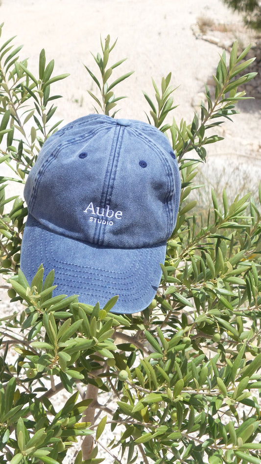 Aube Baseball Cap White Embroidery by Aube Studio in Vintage Light Denim - Front on olive tree view - Unisex oversized fit - Aube Studio